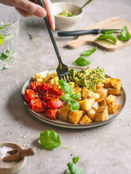Herzhafte vegane Frühstücksbowl mit Ofenkartoffeln, Tofu-Rührei und Guacamole